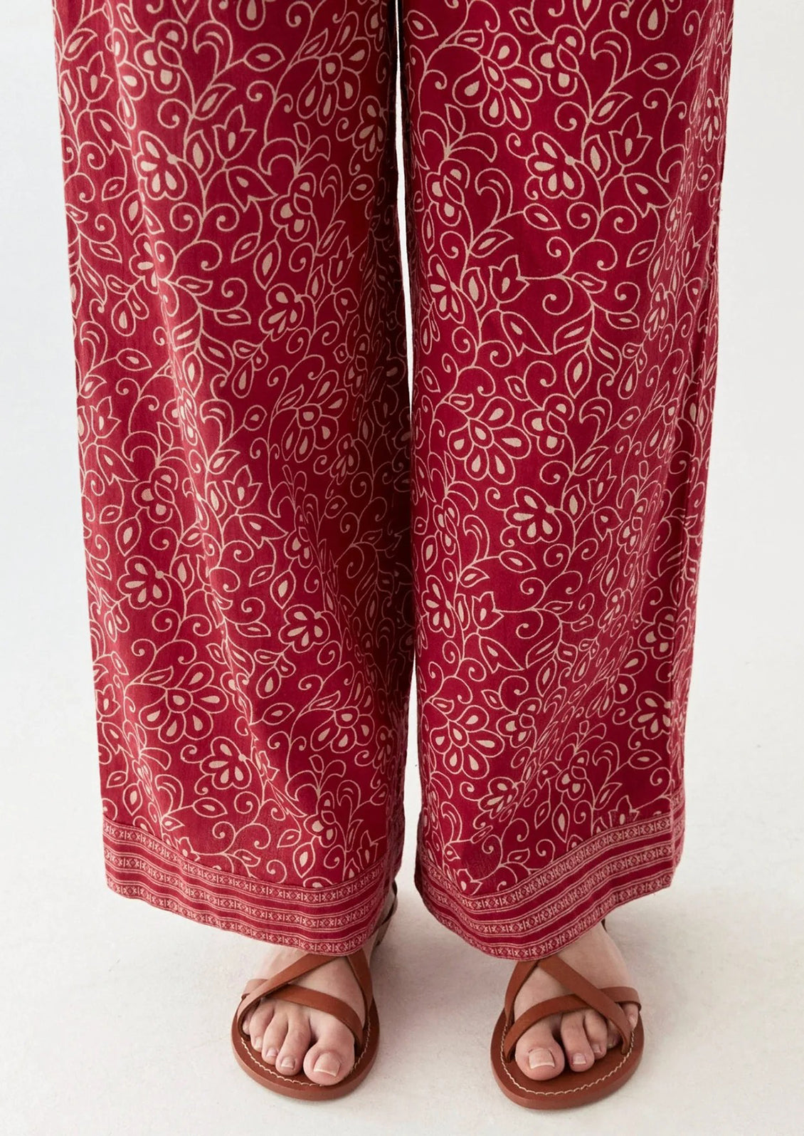 A person wearing a pair of red paisley patterned pants.