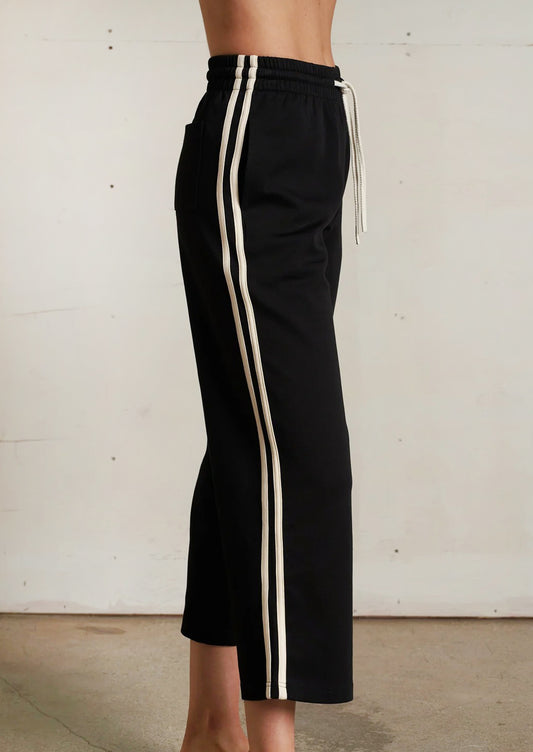 Black pants with white stripes on a plain background