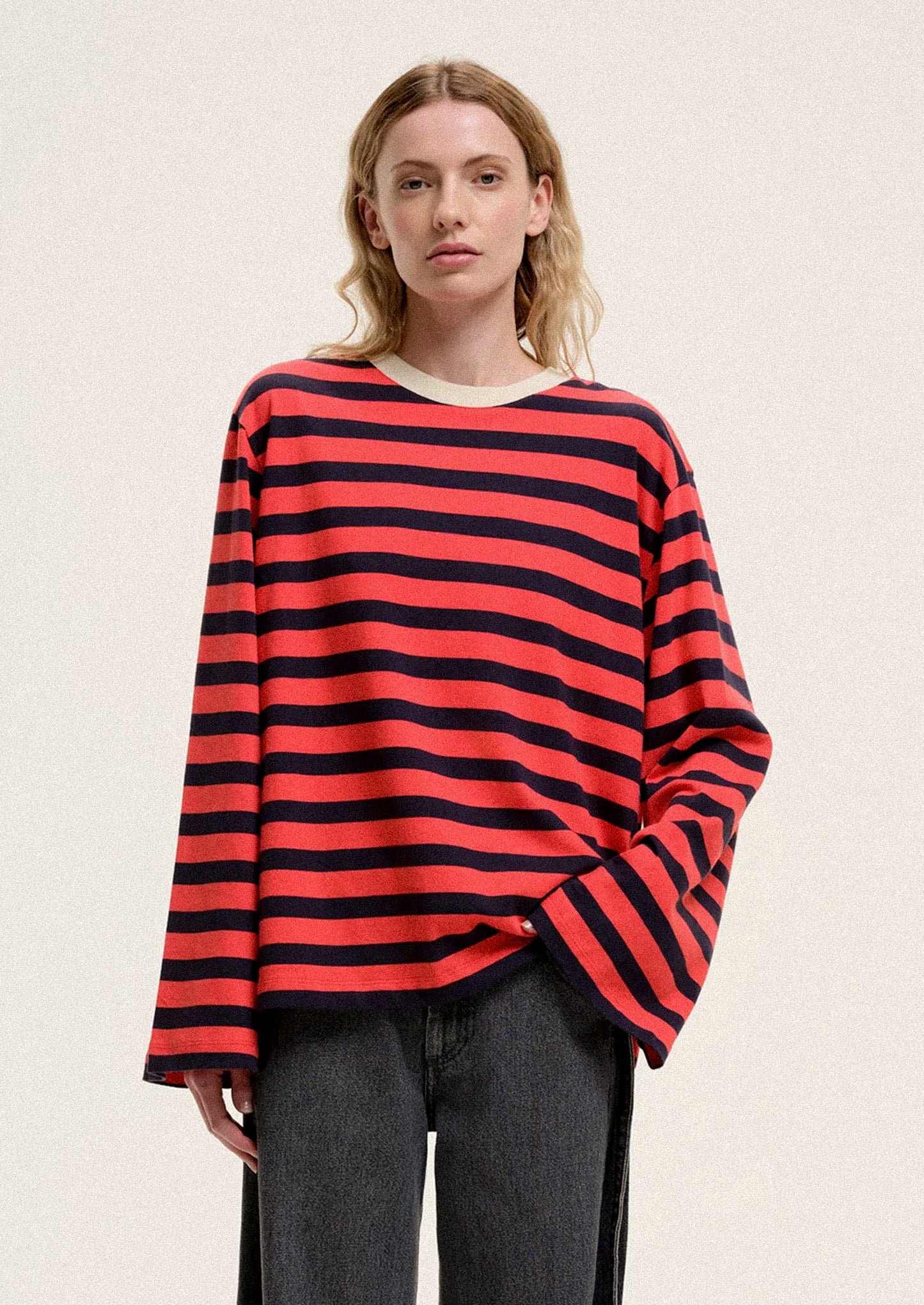 Person wearing a red and black striped sweater on a plain background