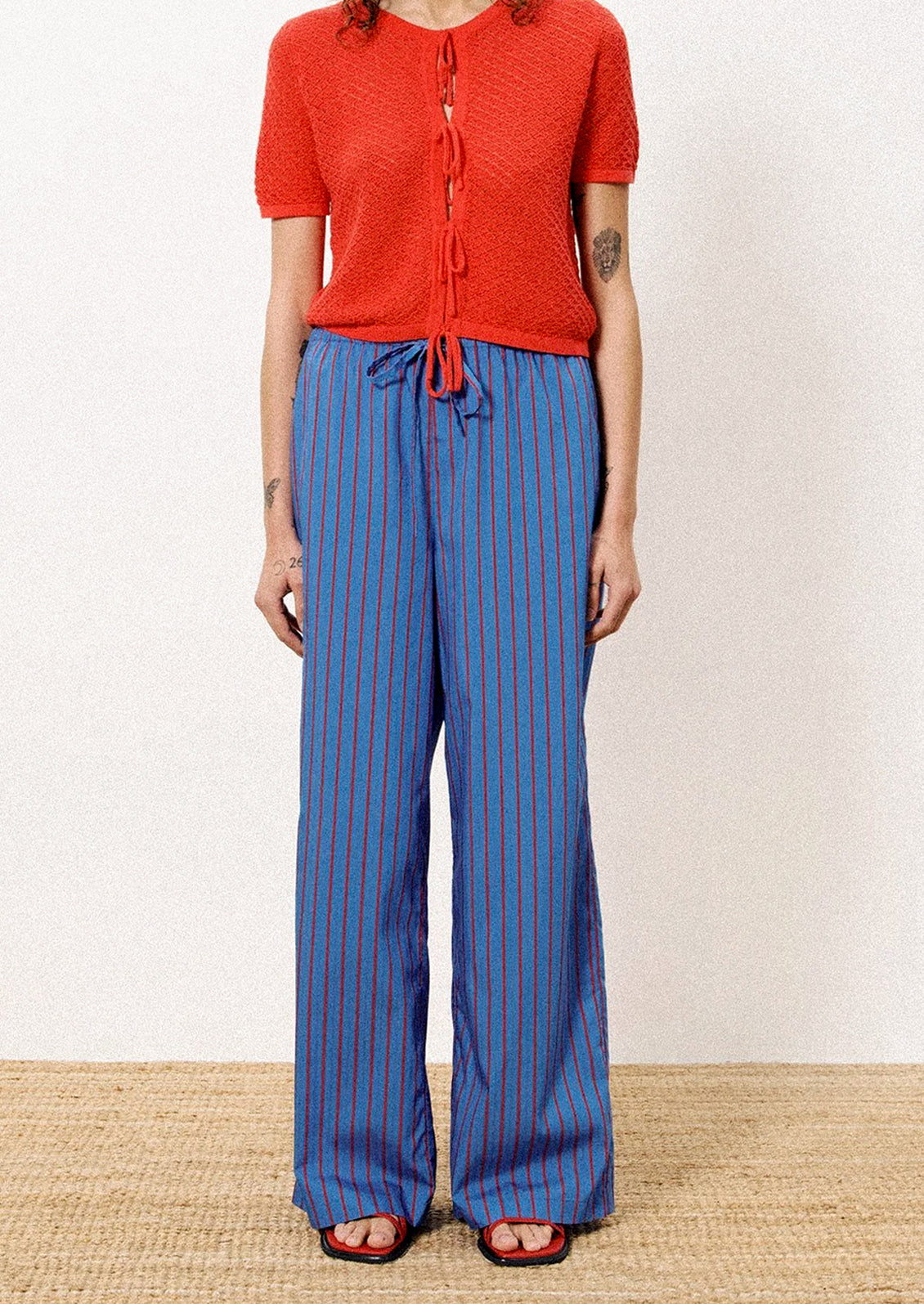 A person wearing a pair of blue and red striped long pants.