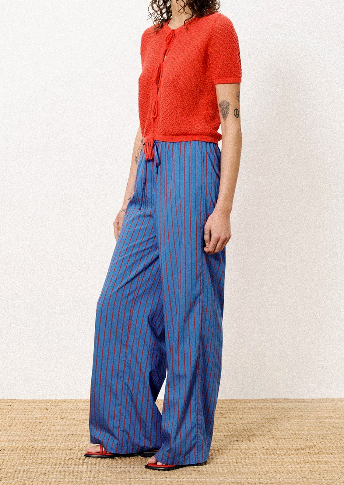 A person wearing a pair of blue and red striped long pants.
