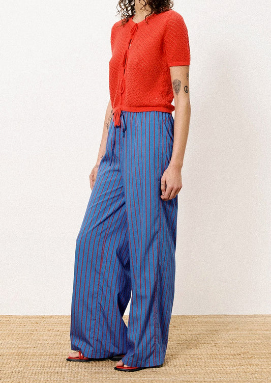 A person wearing a pair of blue and red striped long pants.