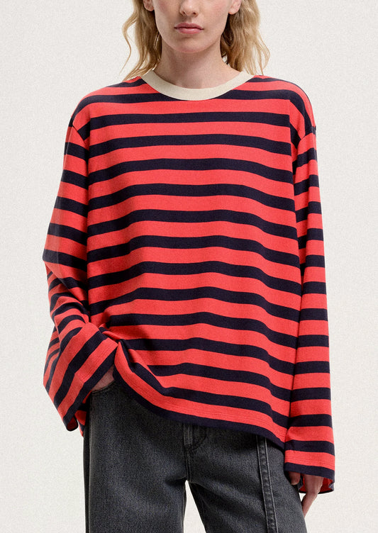 Person wearing a red and black striped sweater on a plain background