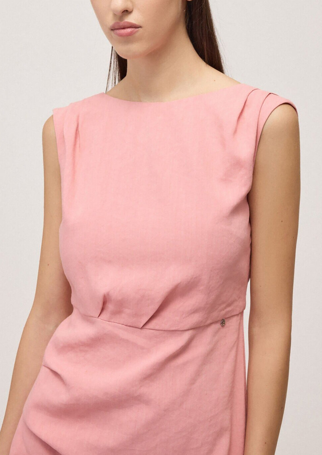 Pink sleeveless dress worn by a model on a plain background