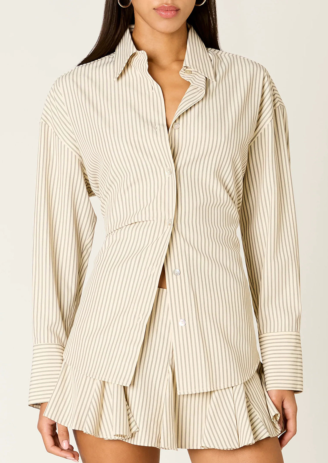 Woman wearing a tan stripe button-up shirt.