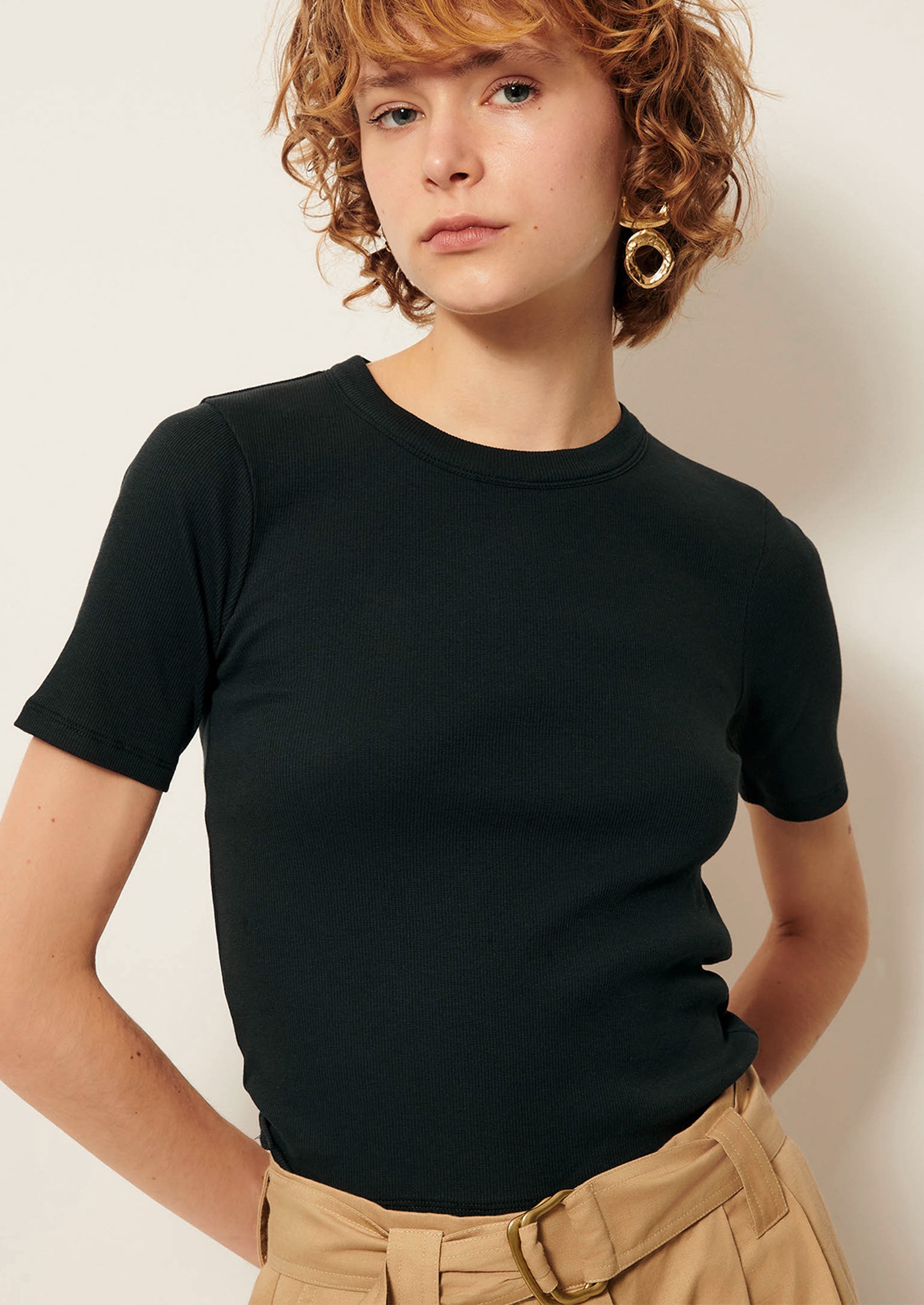 A person wearing a dark short sleeve t-shirt.