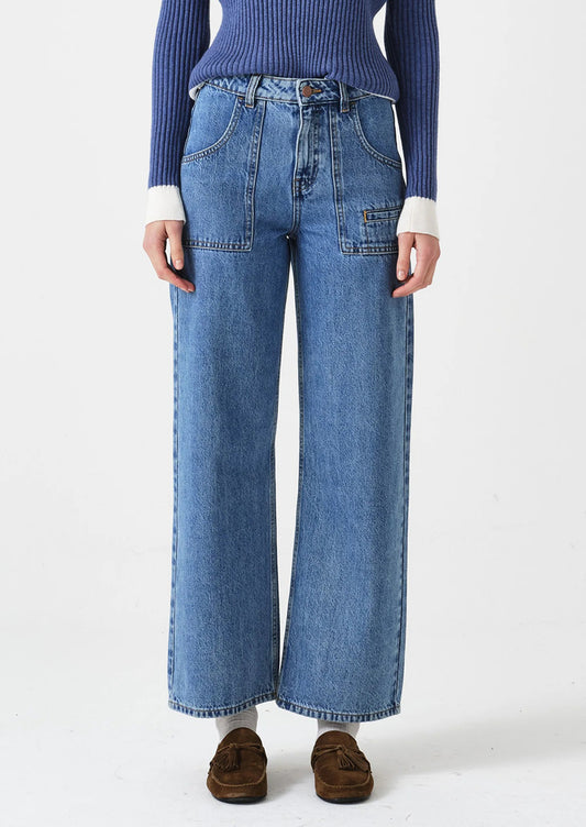 Person wearing blue jeans and a blue sweater on a white background