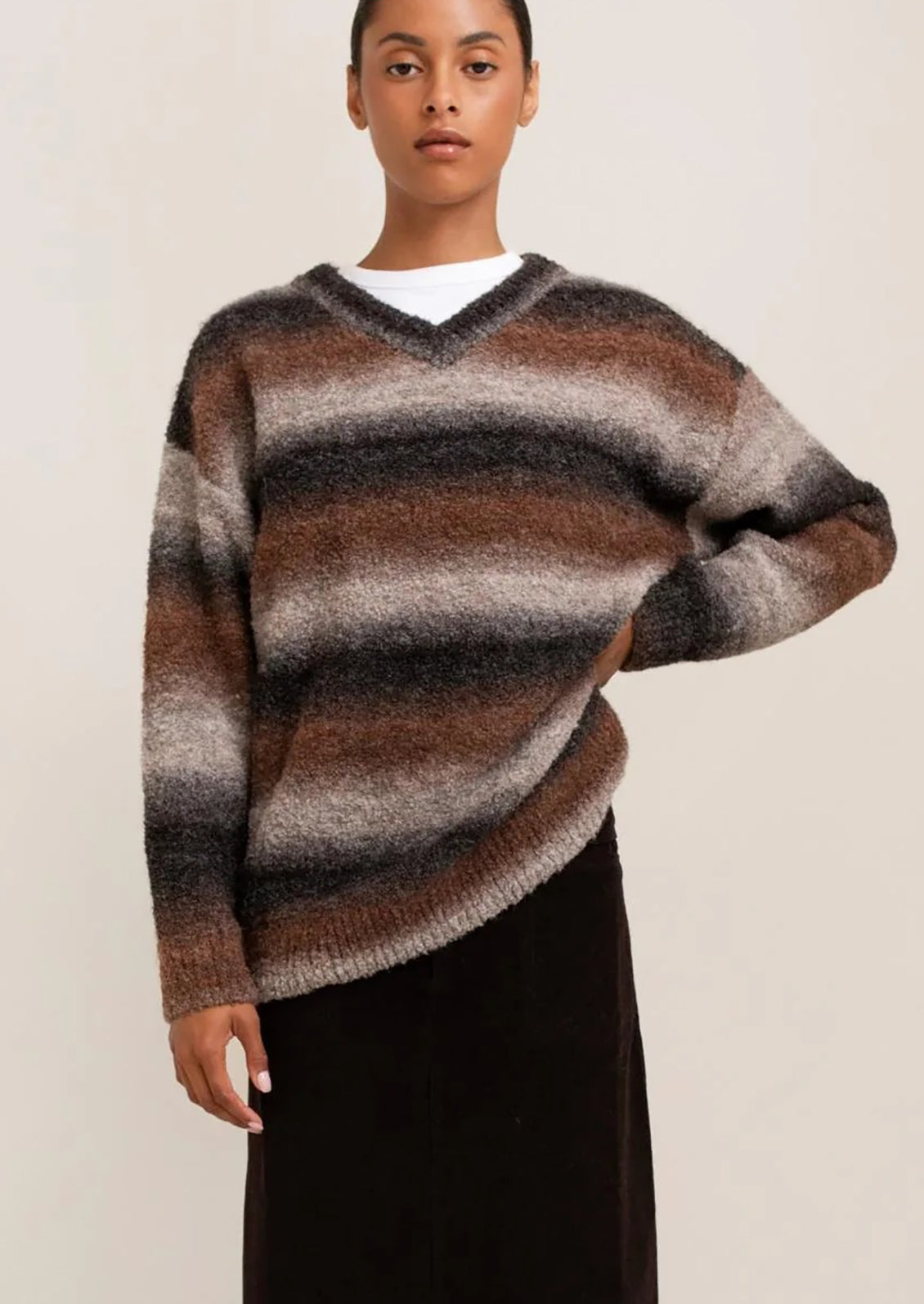 Person wearing a striped sweater with a neutral background