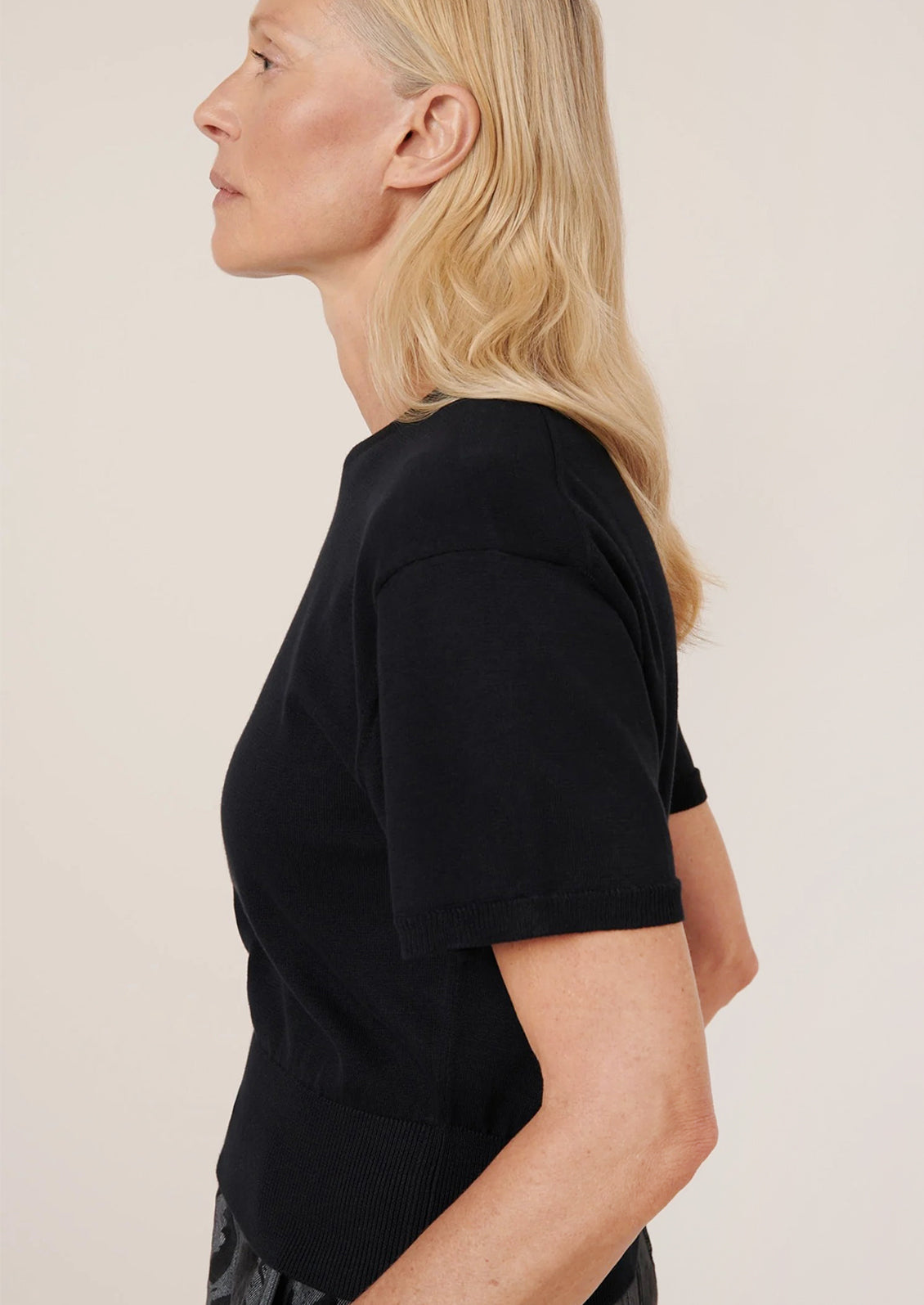 Person wearing a black t-shirt against a plain background