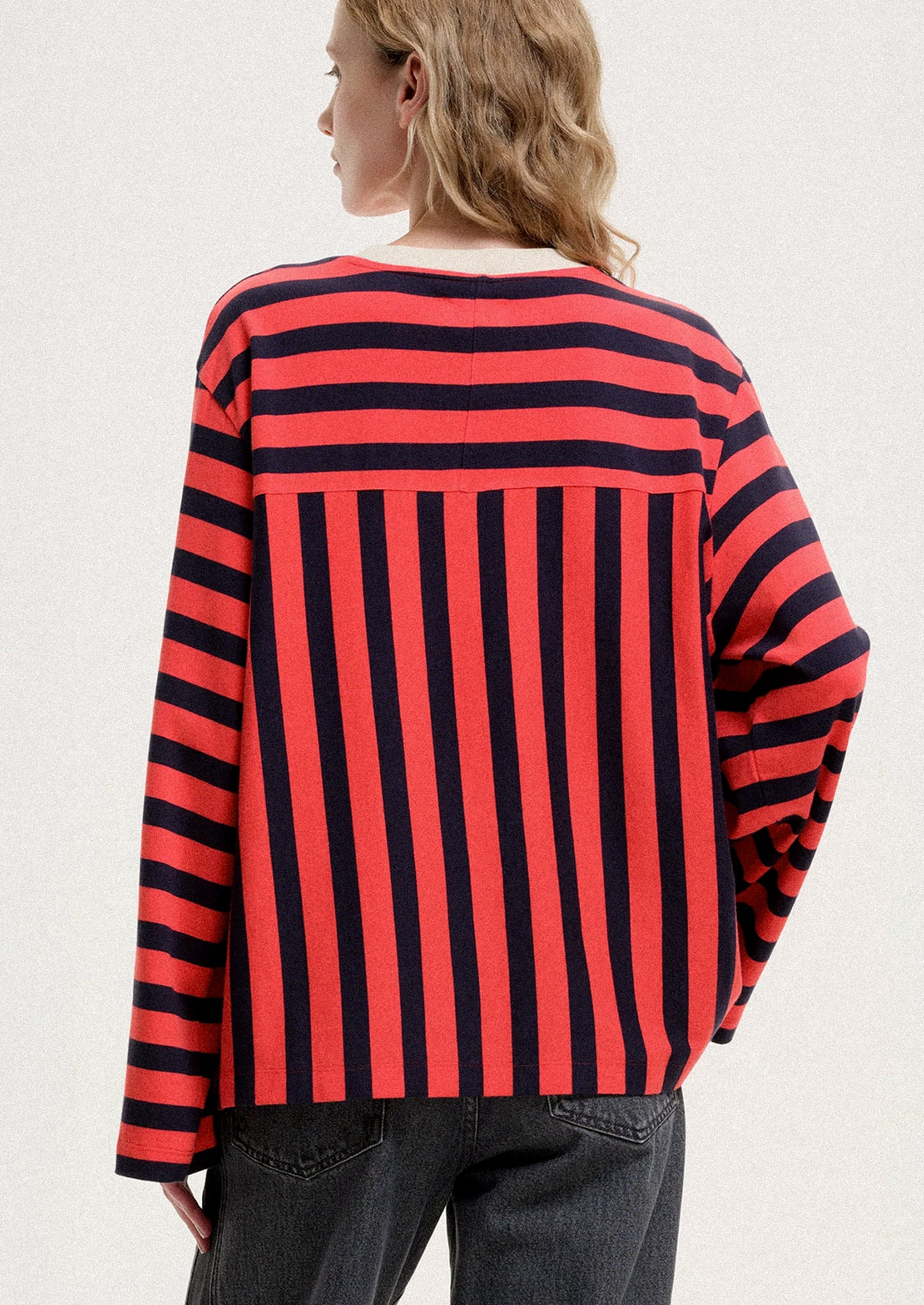 Person wearing a red and black striped shirt on a white background