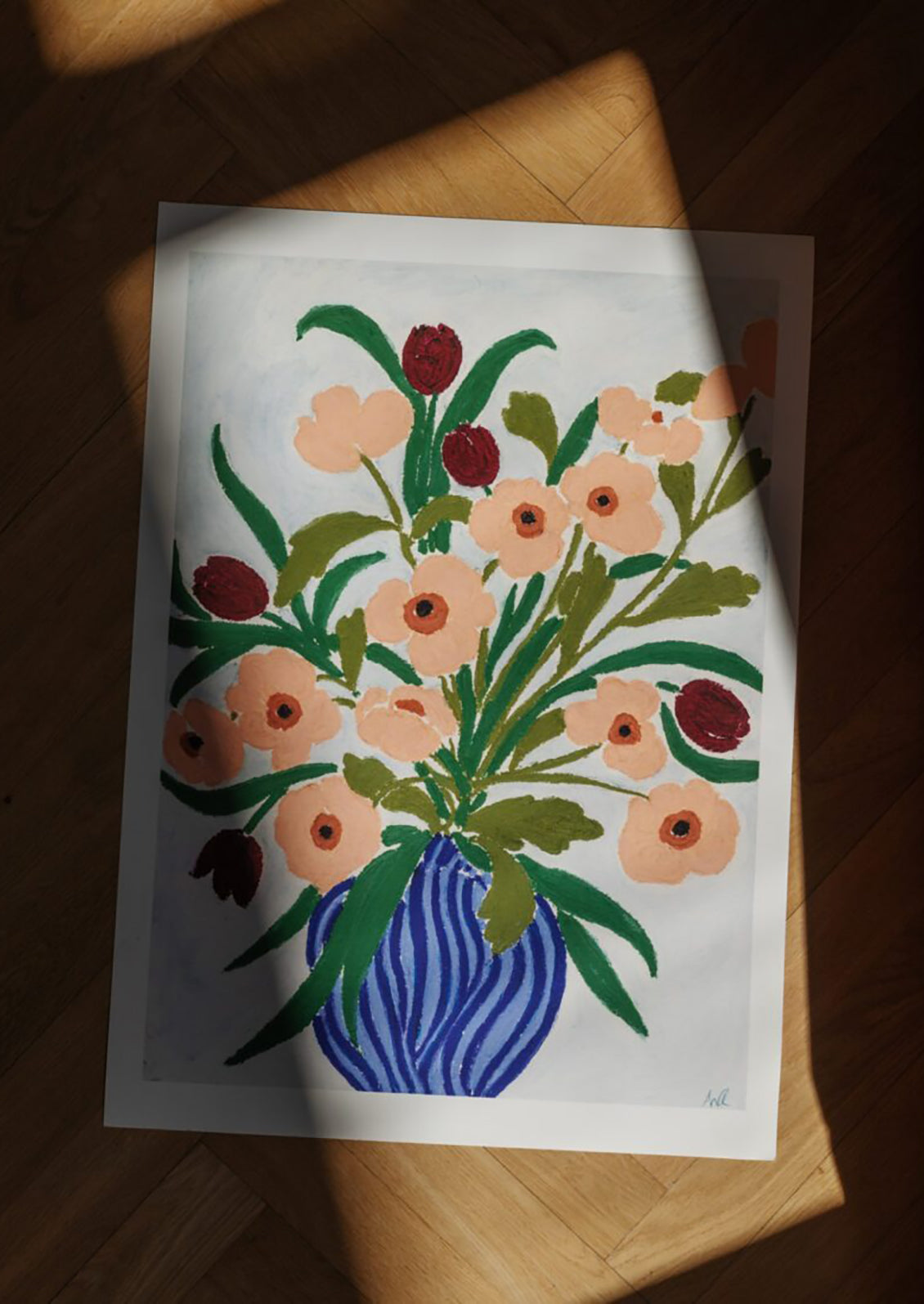 Floral painting on a white sheet of paper with a wooden surface underneath