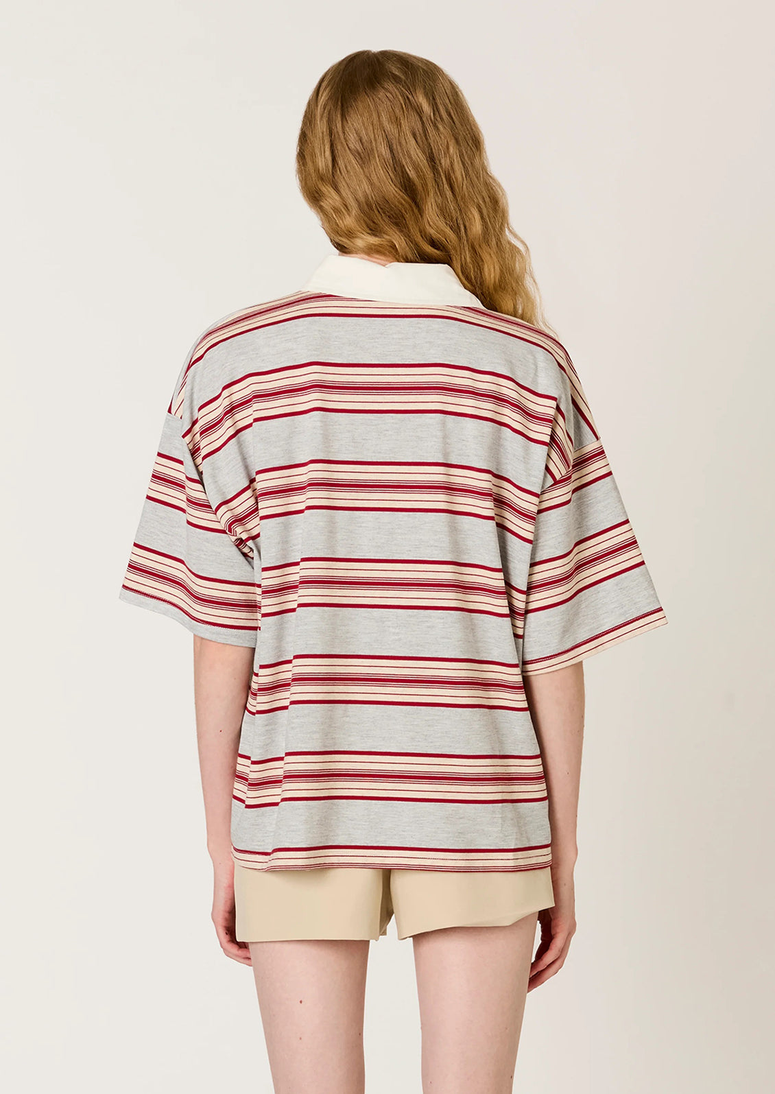 Person wearing a striped shirt and shorts on a plain background
