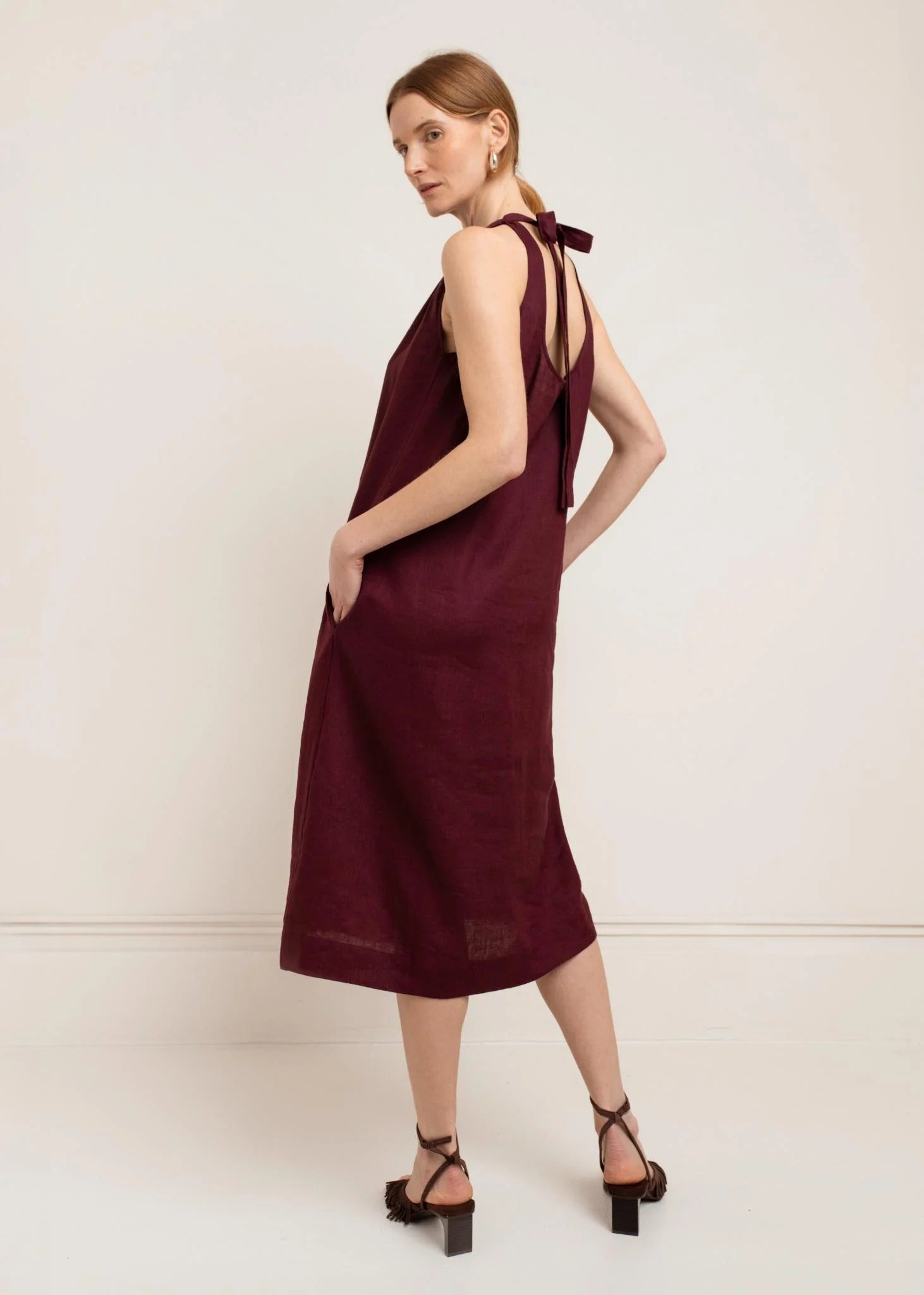 Woman wearing a burgundy dress with a white background