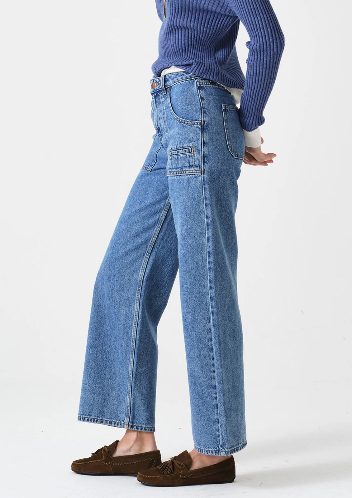 Person wearing blue jeans and a blue sweater on a white background