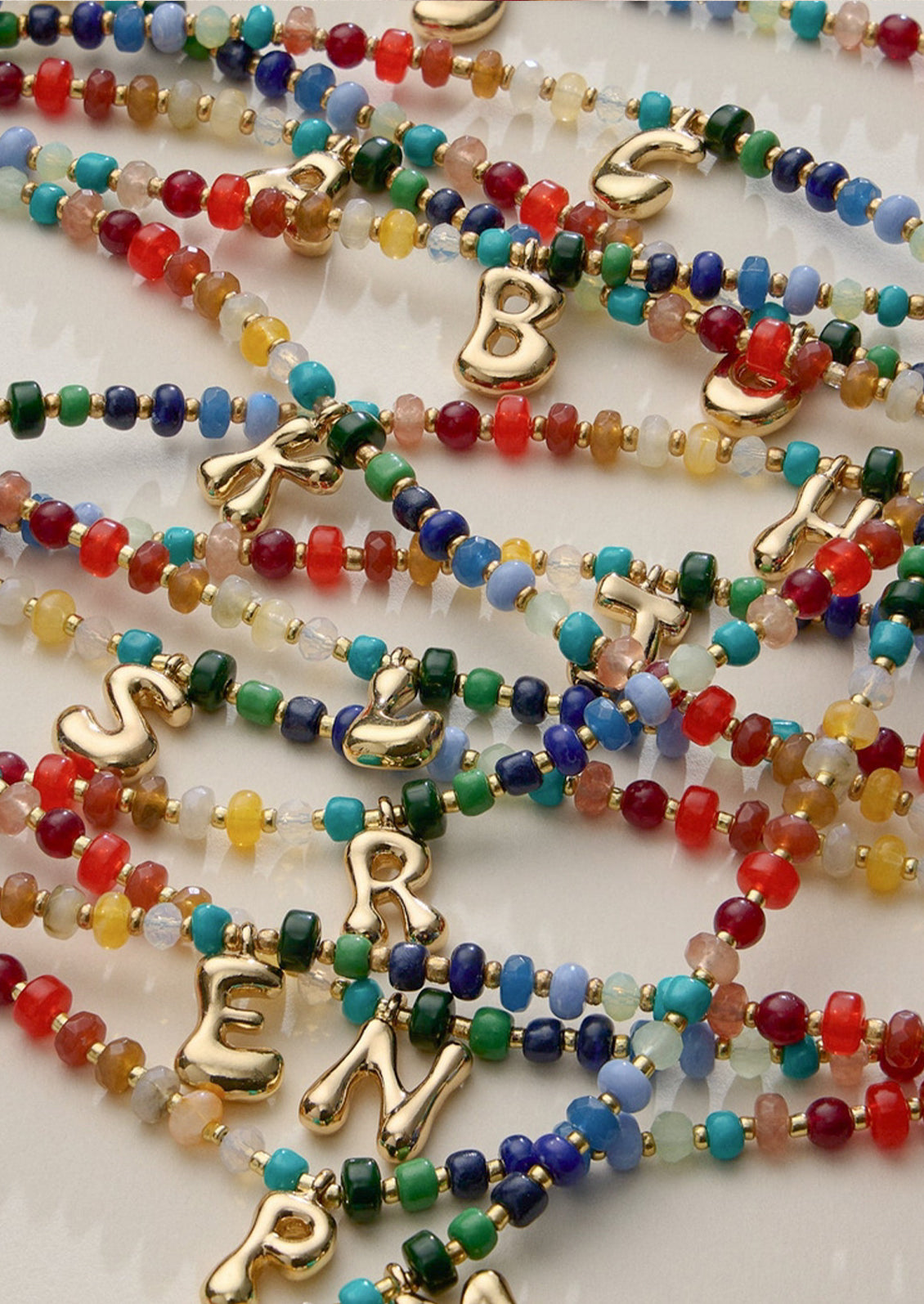 Colorful beaded necklaces with a gold initial charms.