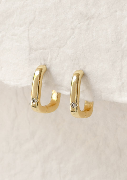 A pair of gold square shaped hoop earrings with a small crystal gem.