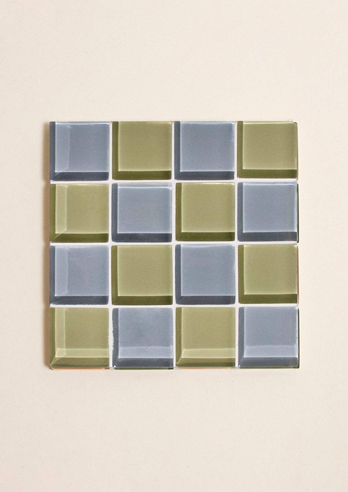 A glass tile coaster in two tone checker pattern in green and grey.