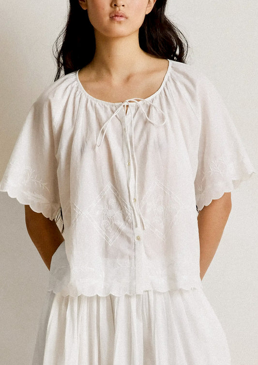 Woman wearing a white dress with a plain background