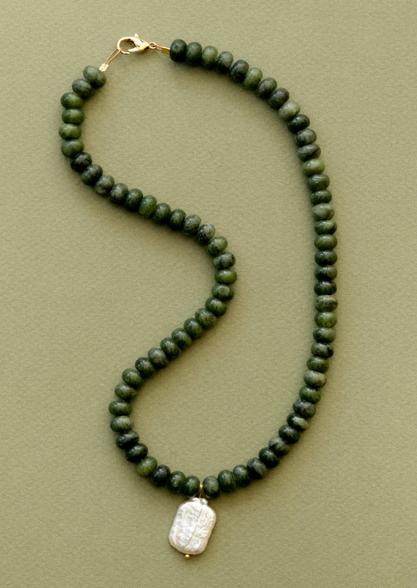 A  necklace with jade beads and pearl pendant.