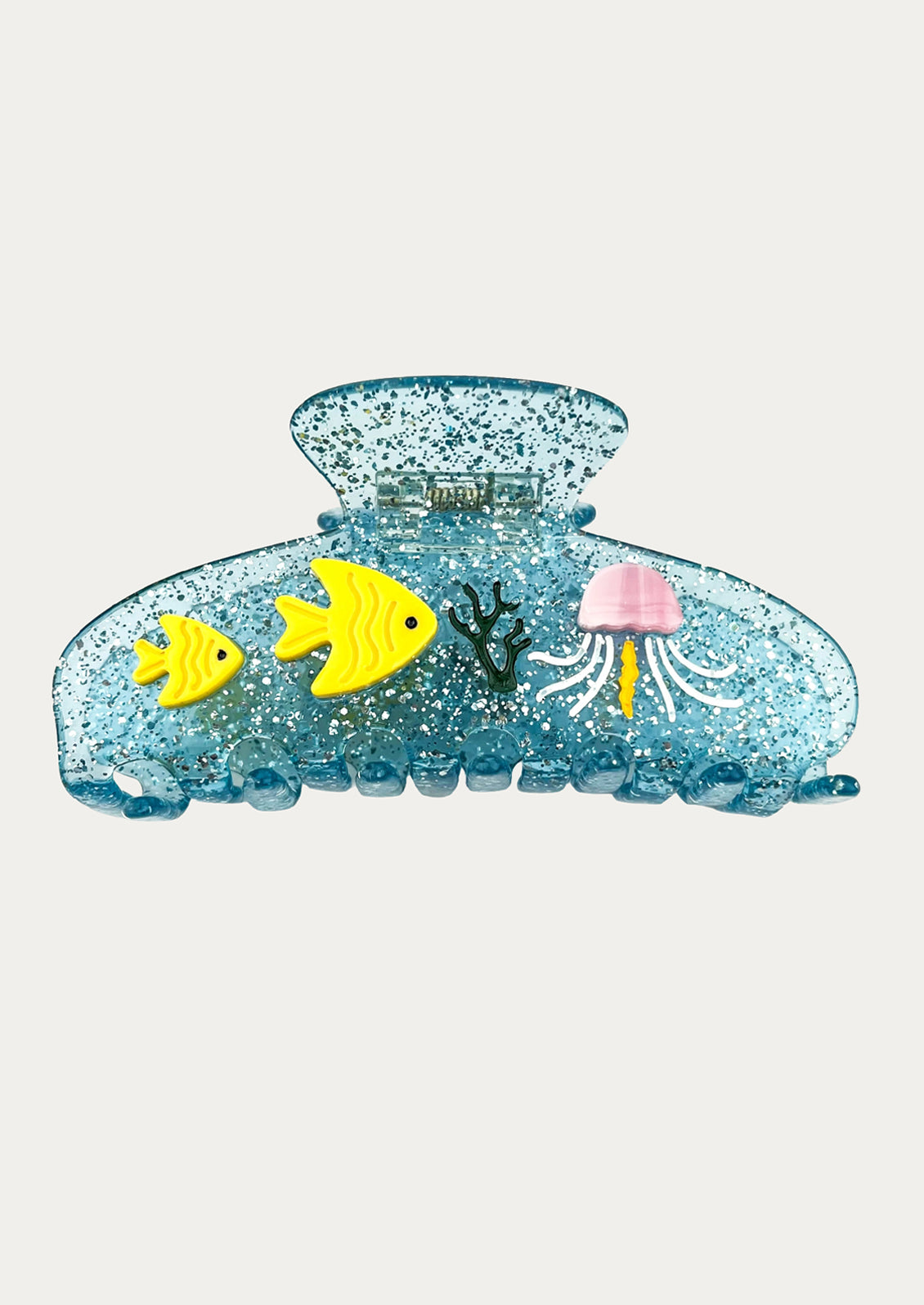 A translucent blue glittery hair claw clip decorated with small yellow fish, a pink jellyfish, and dark green coral details.