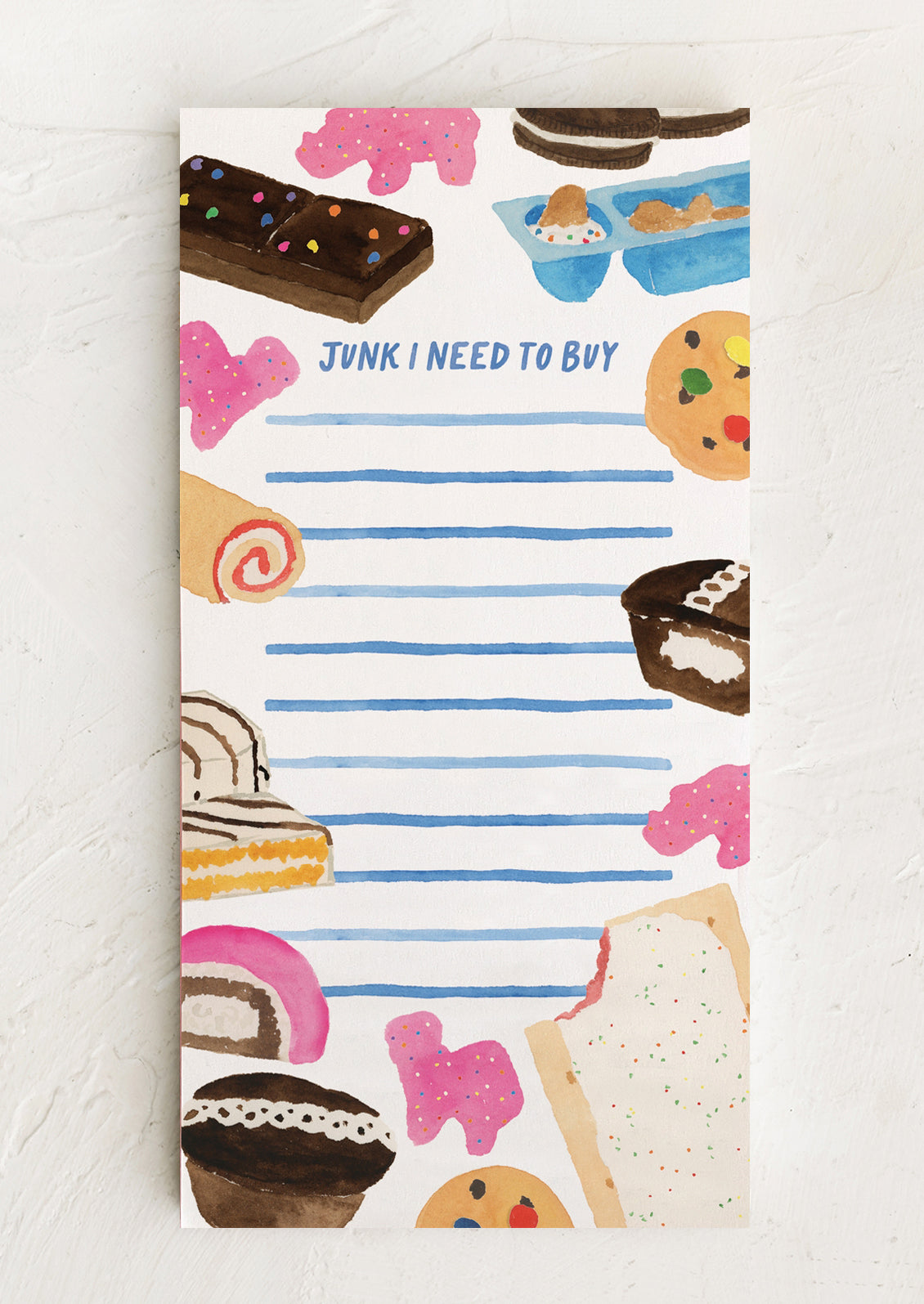 Notepad with food illustrations and text 'Junk I Need to Buy' on a white background