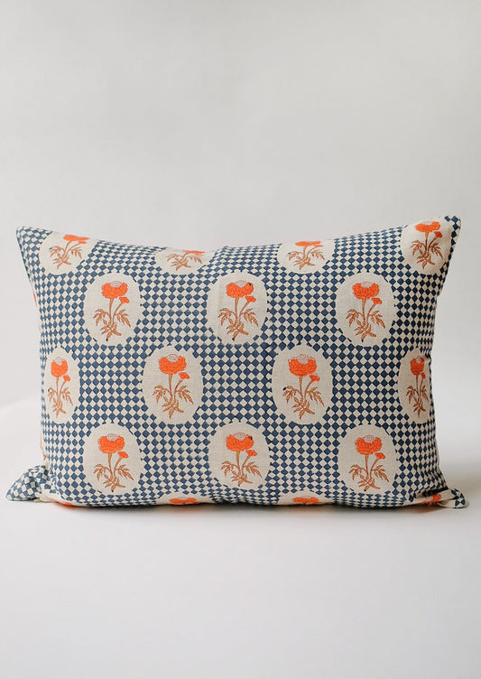 A block printed lumbar pillow with navy diamond checker and orange floral pattern.