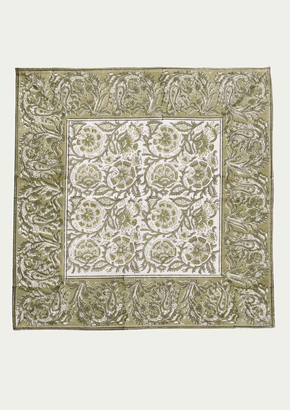 A cloth napkin in green and white traditional floral block print pattern.