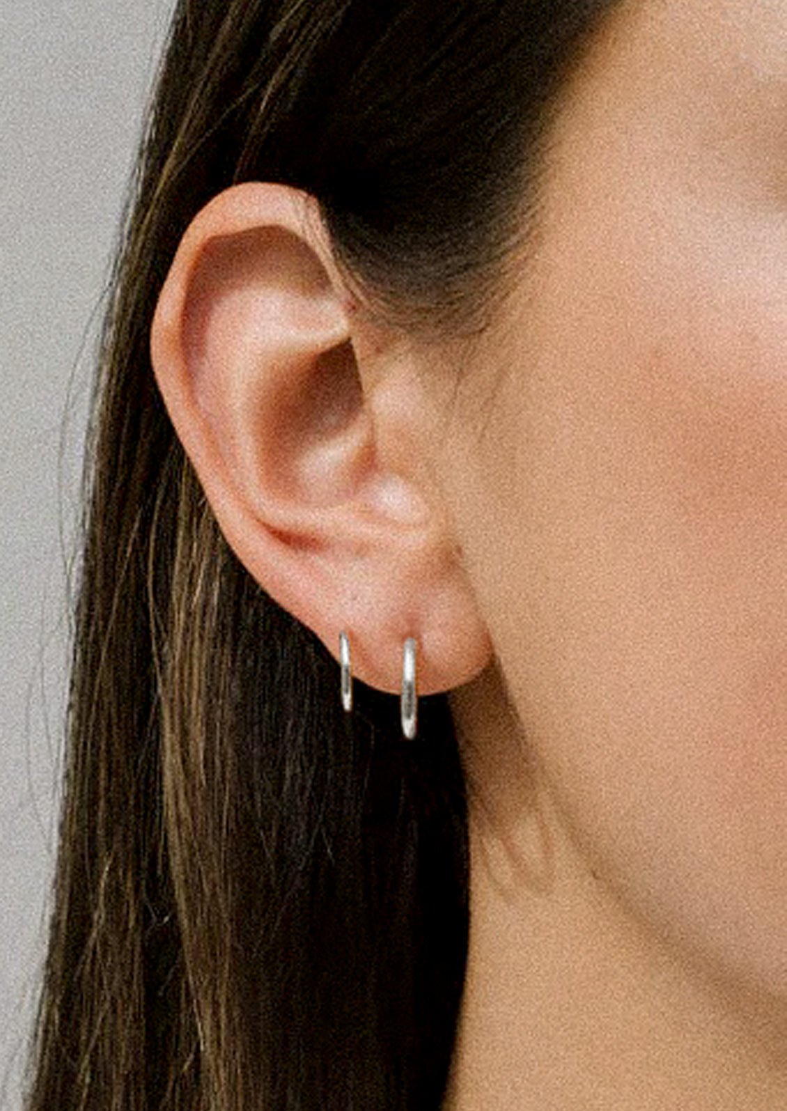 A women wearing a sterling silver earring with two hoops.