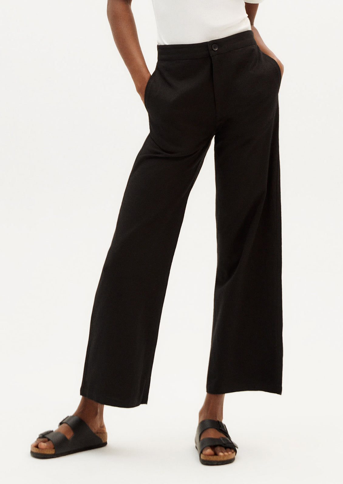 A person wearing a pair of ankle length cotton pants in black with slight wide leg.