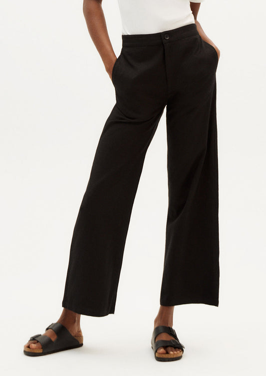 A person wearing a pair of ankle length cotton pants in black with slight wide leg.