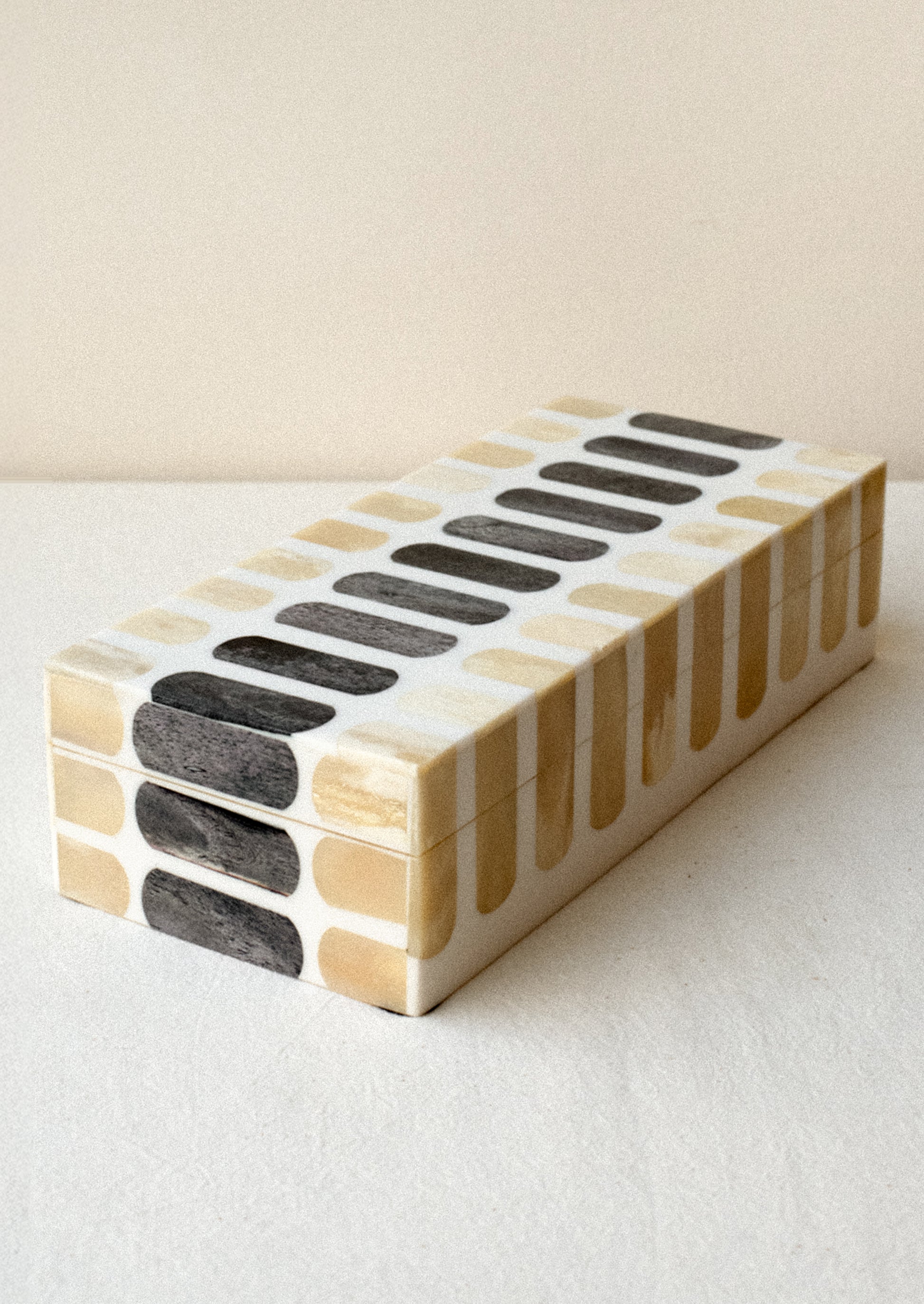 Decorative storage box made from bone with tan and grey inlay.