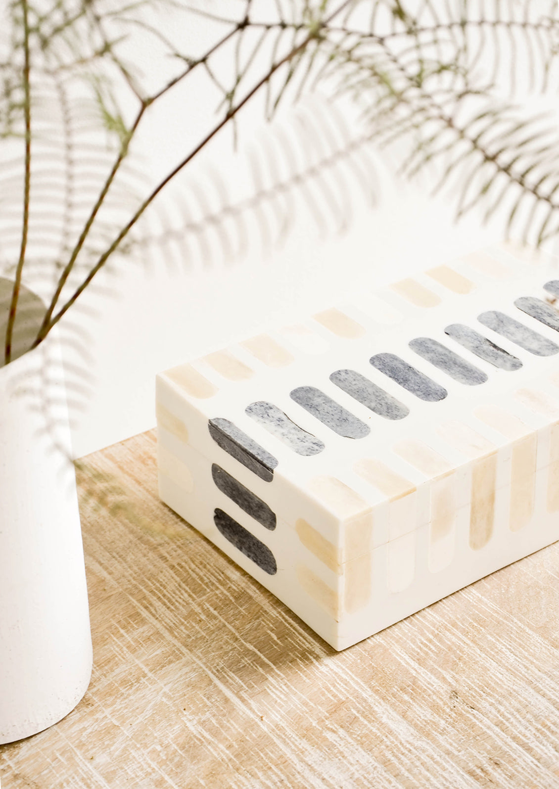 Decorative storage box made from bone with tan and grey inlay.