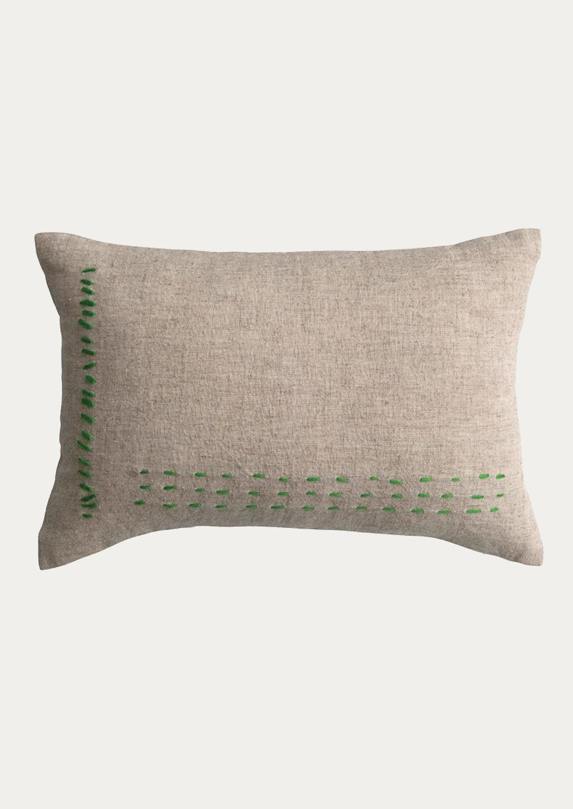 A linen lumbar pillow in natural linen with kelly green stitching.