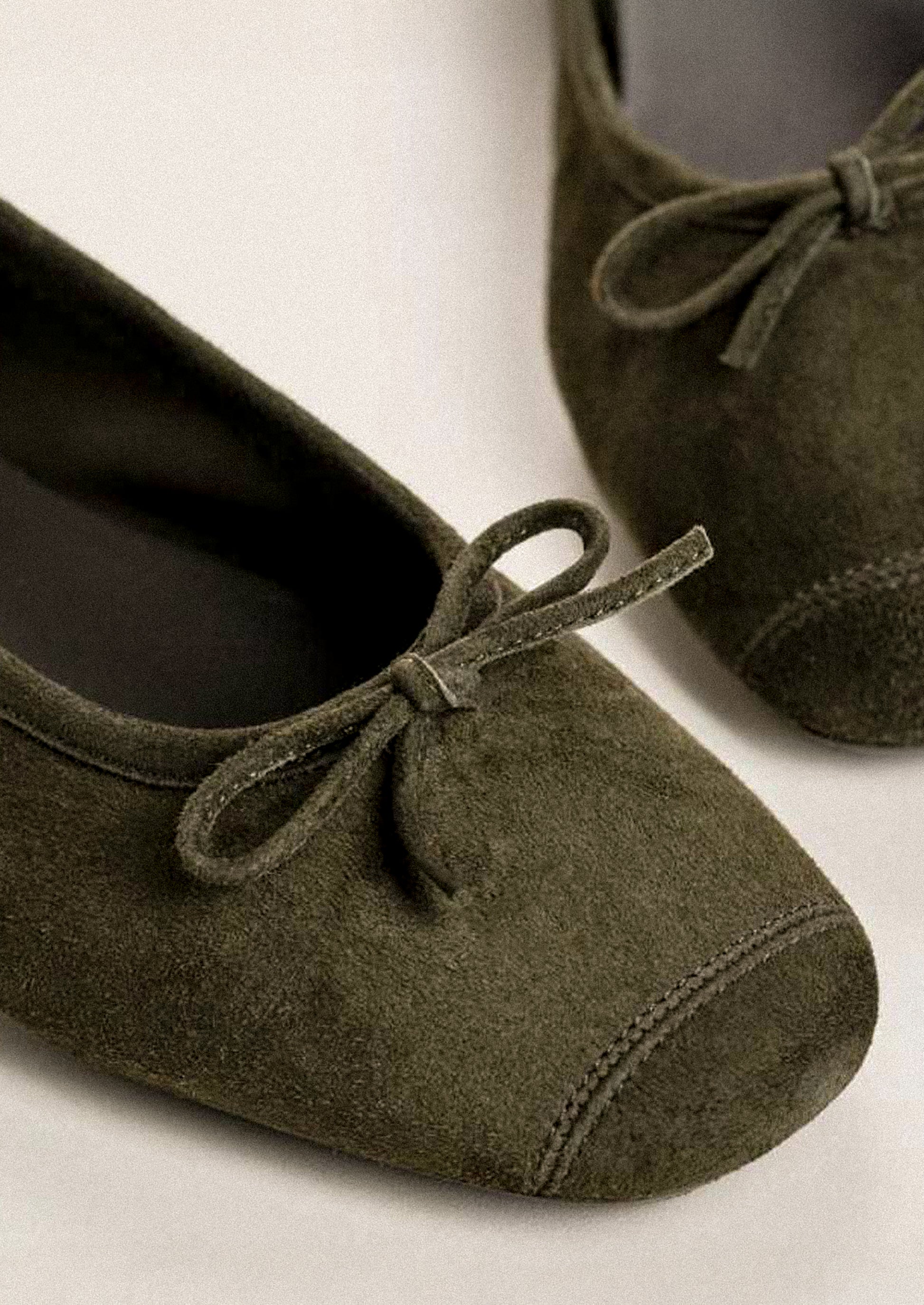 A pair of suede ballet flats in khaki green.