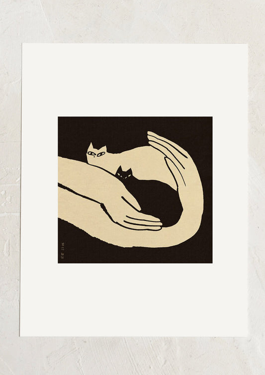 An art print in black and white of two kittens resting in human hands.