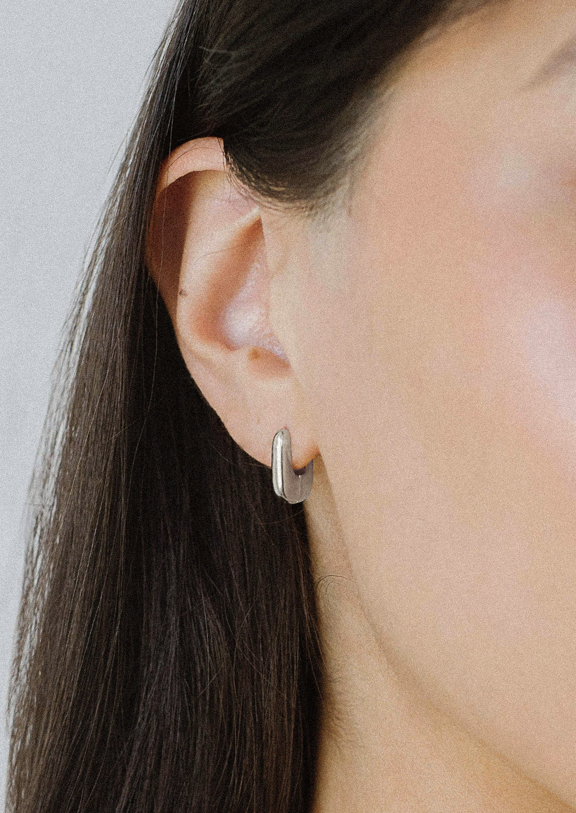 A woman wearing a sterling silver hoop earring.