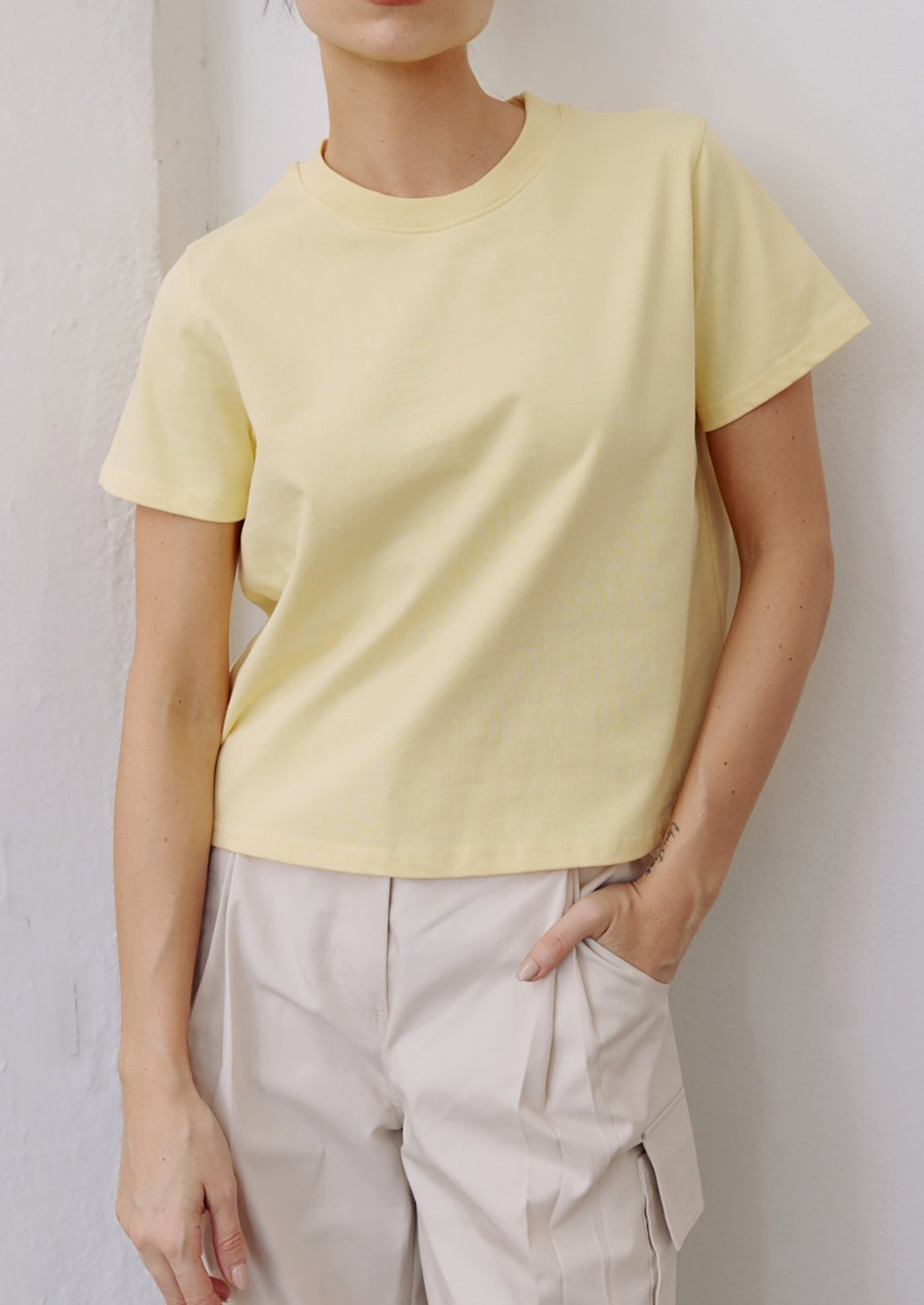 A woman wearing a butter yellow t-shirt.