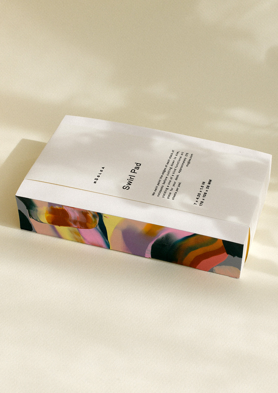 A chunky notepad with rainbow painted side.