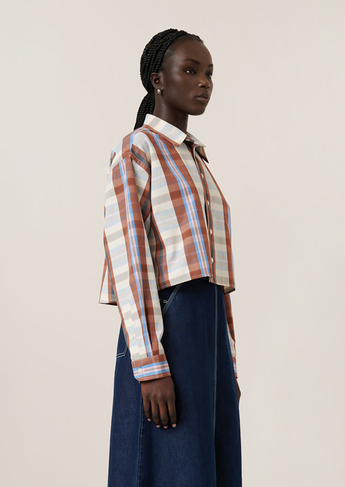 A woman wearing a multicolor plaid cropped shirt.