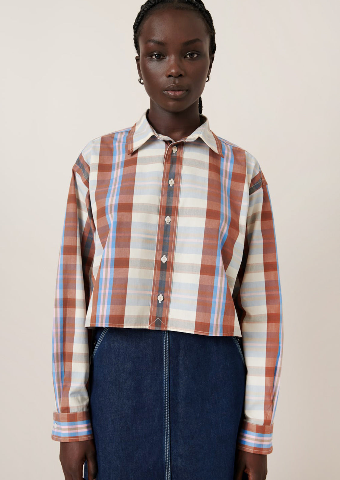 A woman wearing a multicolor plaid cropped shirt.