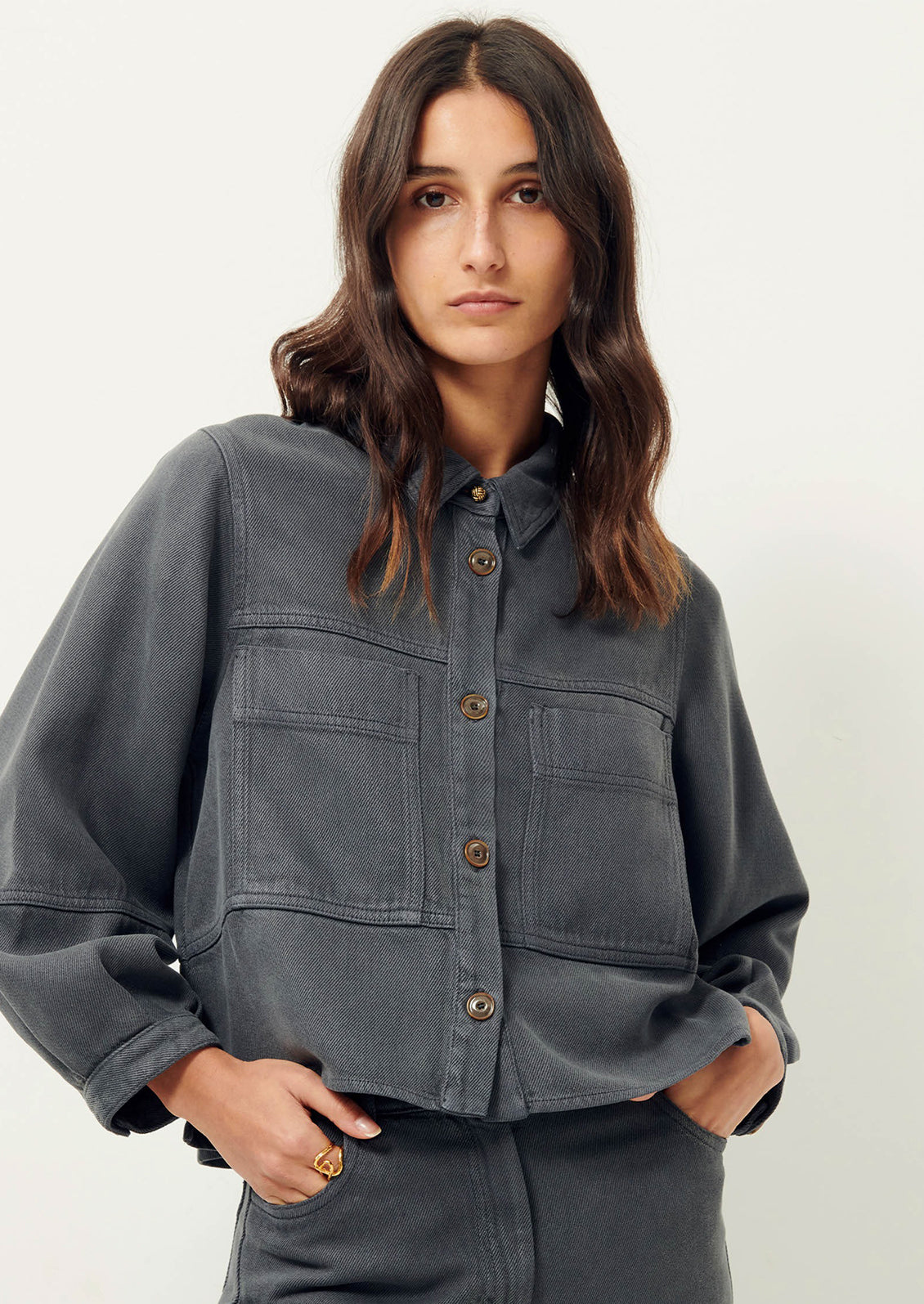 Woman wearing dark gray denim shirt jacket. 