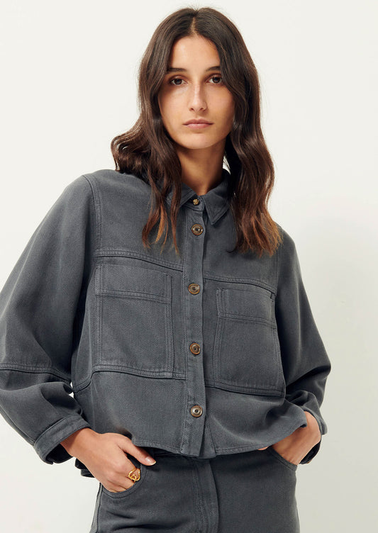 Woman wearing dark gray denim shirt jacket. 
