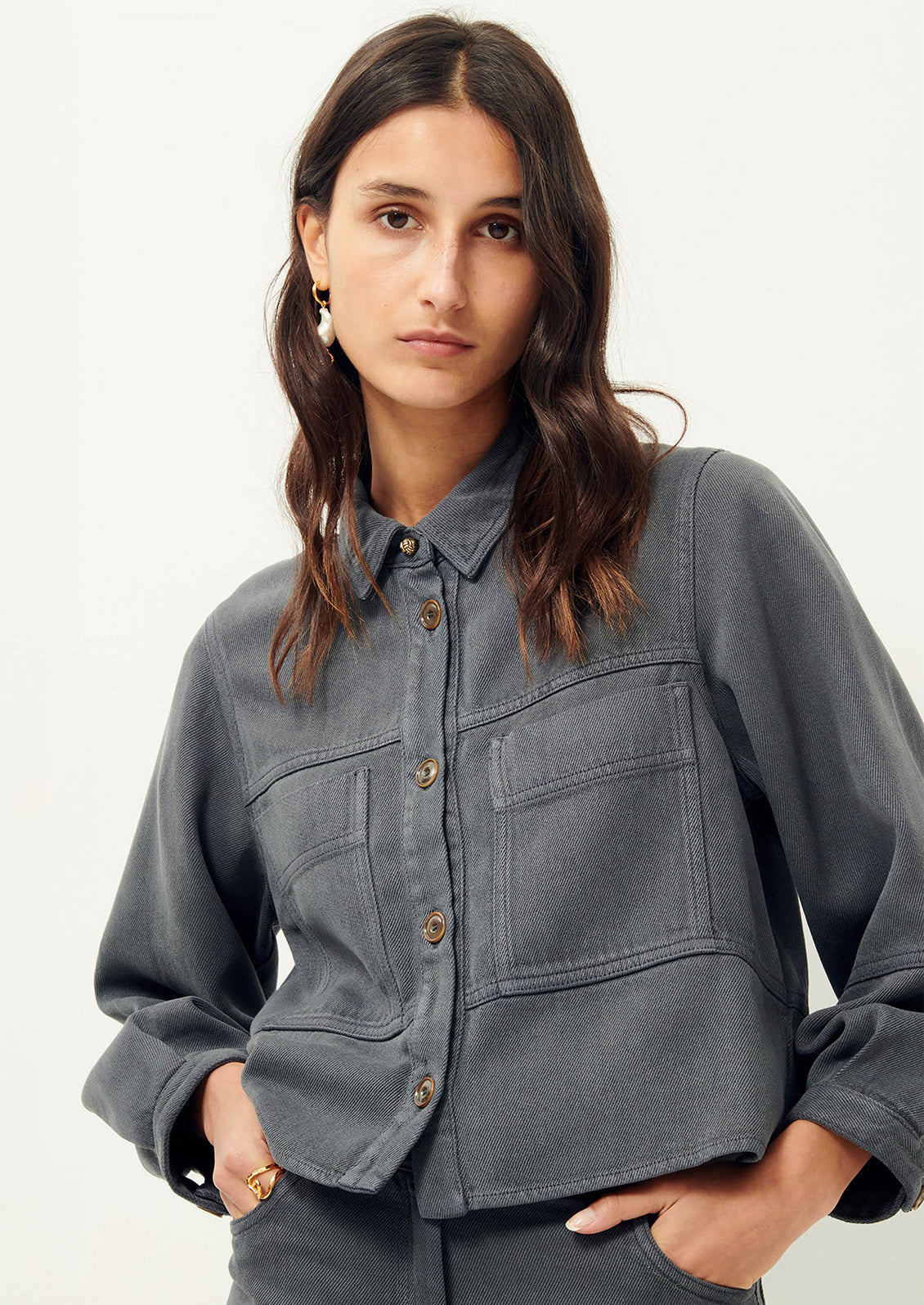 Woman wearing dark gray denim shirt jacket. 