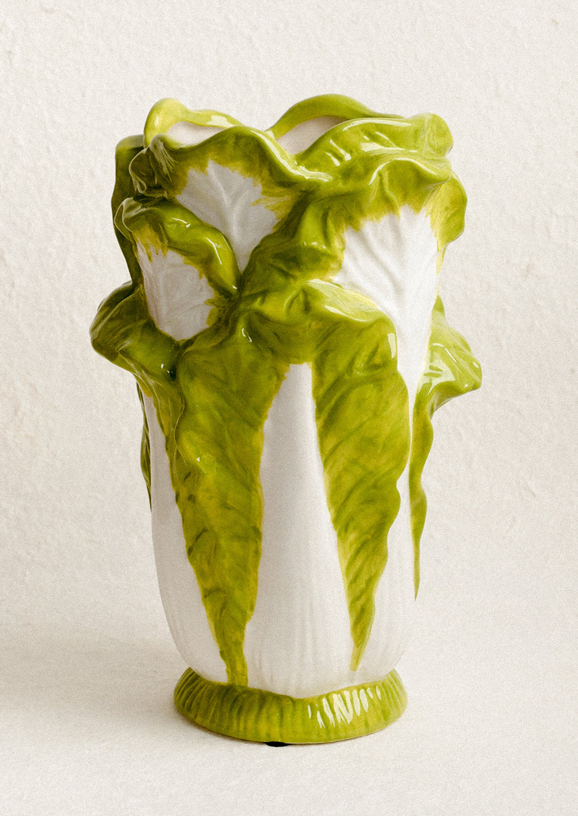 Vase designed to look like a head of lettuce on a white background