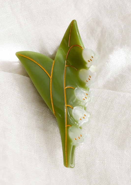 A hair claw in the shape of lily of the valley plant.