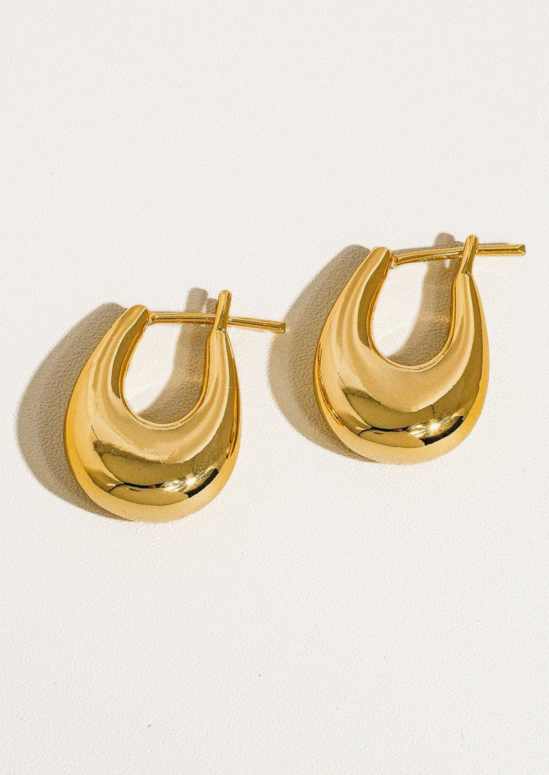 A pair of bold chunky oblong shape earrings in gold.