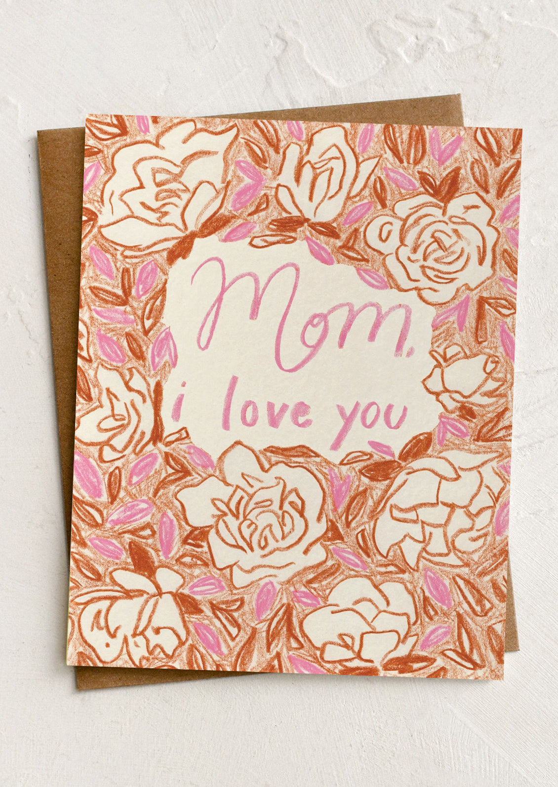 Greeting card with floral design and 'Mom, I love you' text on a textured surface