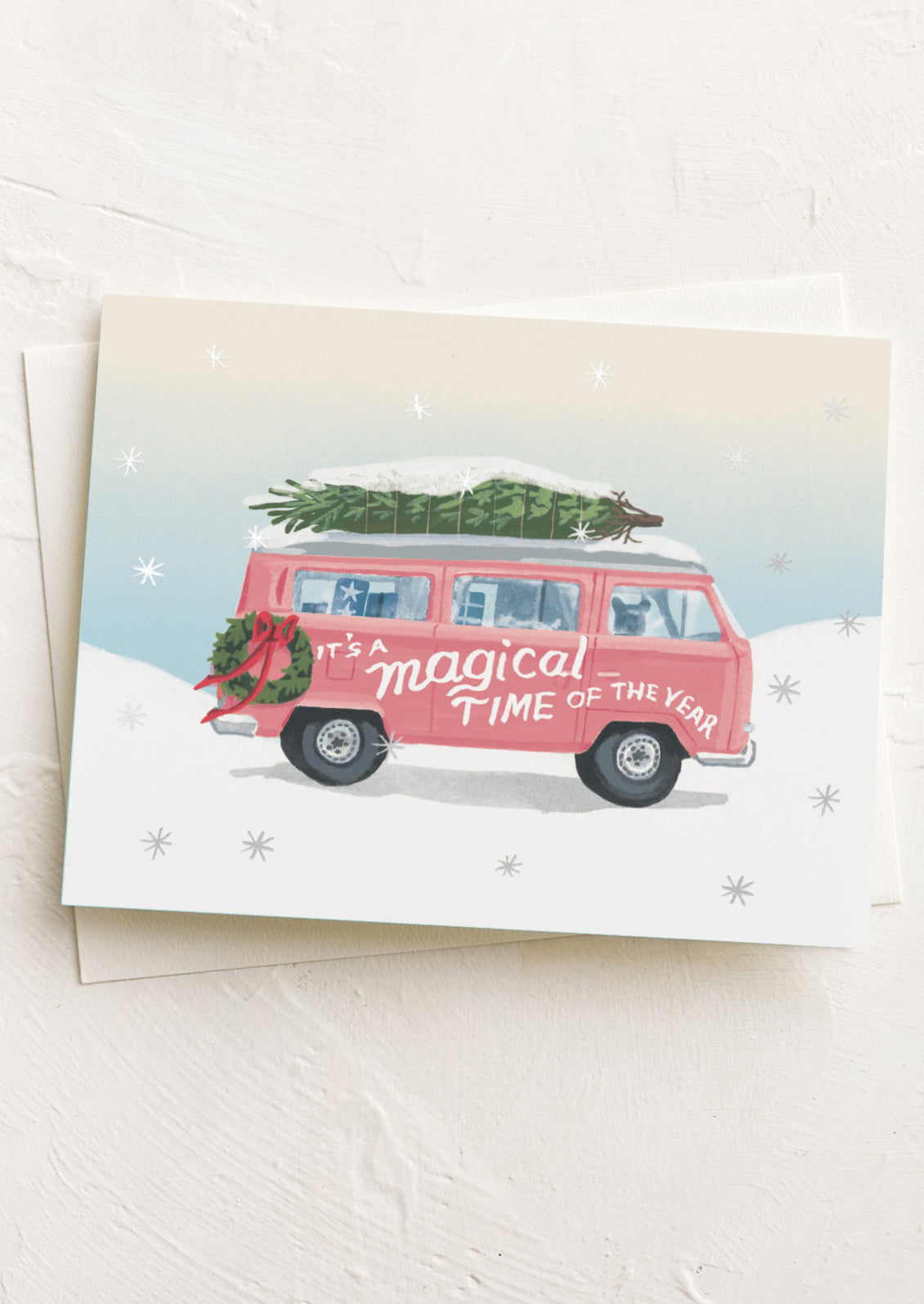 Christmas card with a pink van carrying a Christmas tree and 'It's a Magical Time of the Year' text.