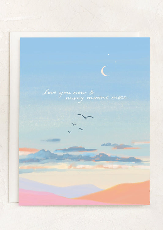 An illustrated card of sunset and clouds, text reads "Love you now & many moons more".