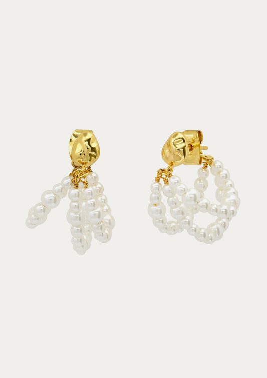 A pair of  earrings that have three strands of faux pearls.